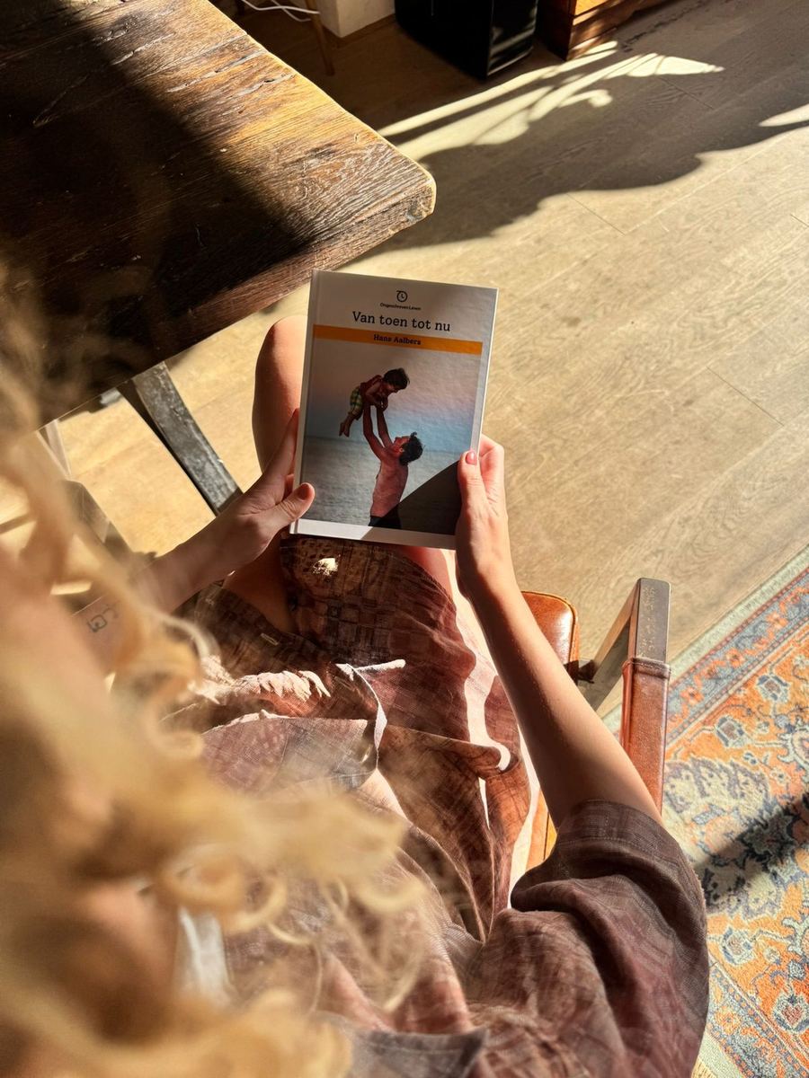 Vrouw bladert thuis door haar eigen gedrukte levensboek