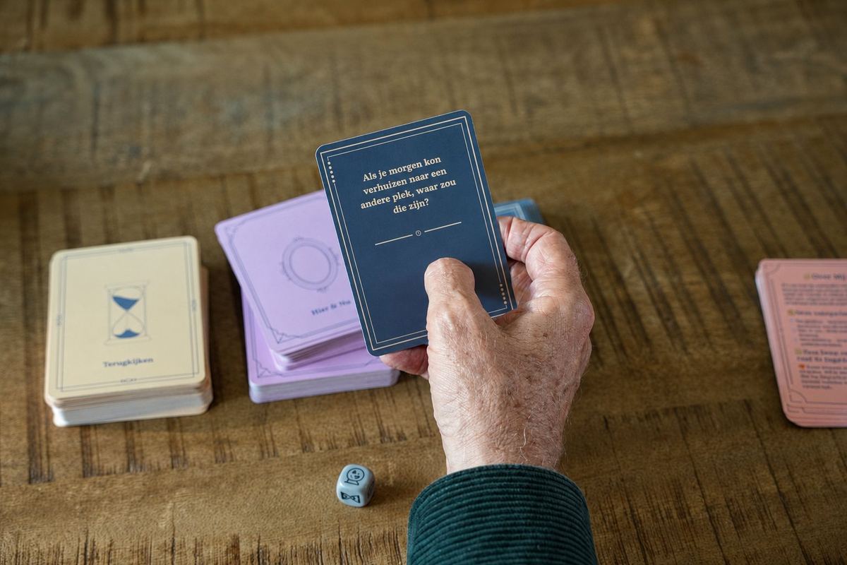 Oudere hand houdt een vraagkaart van het Familiegesprekken kaartspel vast