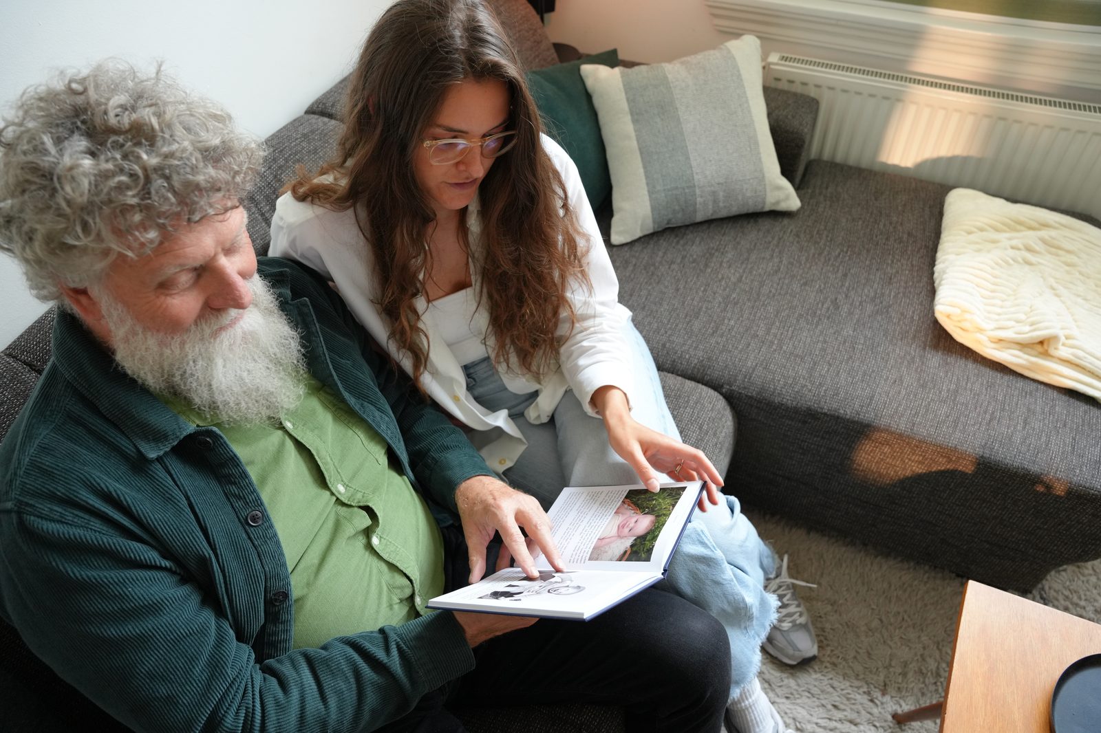 Man leest rustig het voltooide levensboek bij het raam
