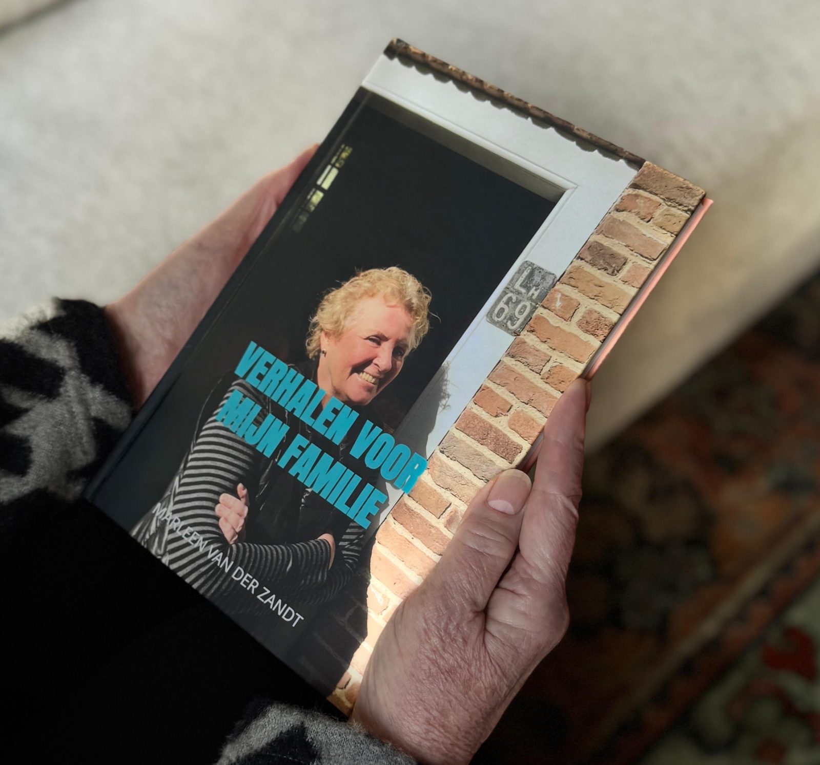 Handen houden het voltooide hardcover levensboek Verhalen voor mijn familie vast